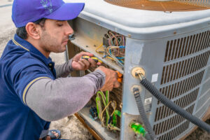 HVAC contractor working on AC unit